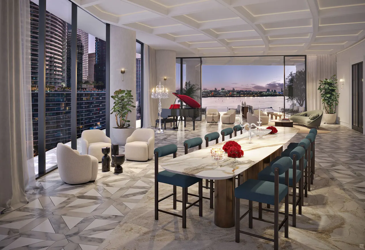 Formal dining room with long marble table, teal chairs, grand piano and floor-to-ceiling city and water views