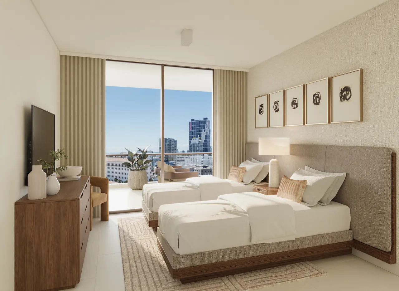 Guest bedroom with two queen beds, wood dresser and floor-to-ceiling window framing city views