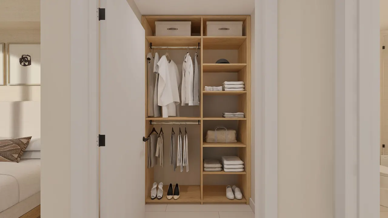 Open built-in closet with light oak shelving, hanging rods and folded linens beside a bedroom