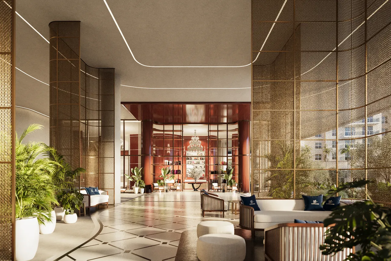 Double-height lobby with brass screen walls, patterned stone floor and lounge seating by a bar