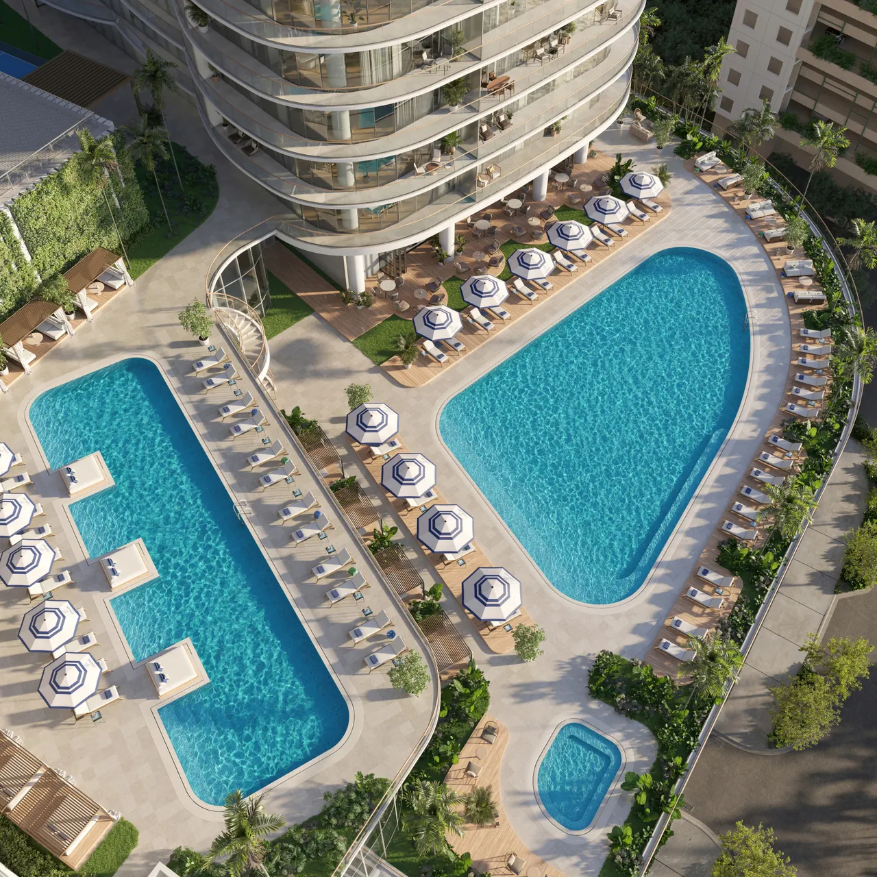 Aerial view of the pool deck with two large pools, striped umbrellas, loungers and cabanas