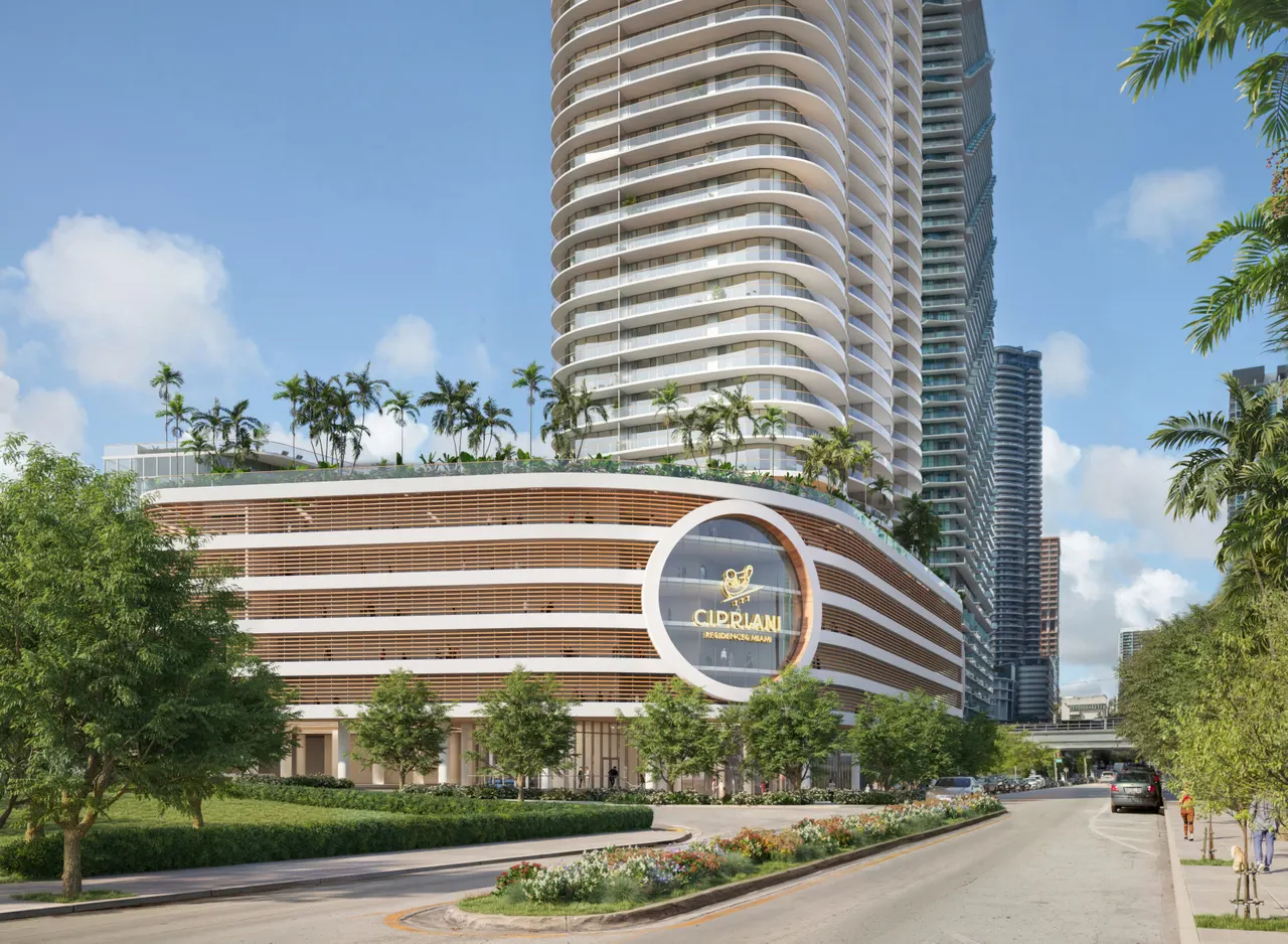 Street-level view of Cipriani Residences with curved wood-slat podium, rooftop palms and tower above