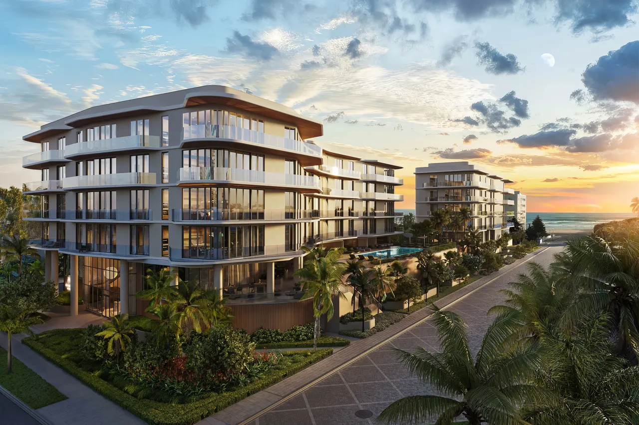 Curved low-rise condominium with glass balconies, palm-lined street and pool deck at sunset