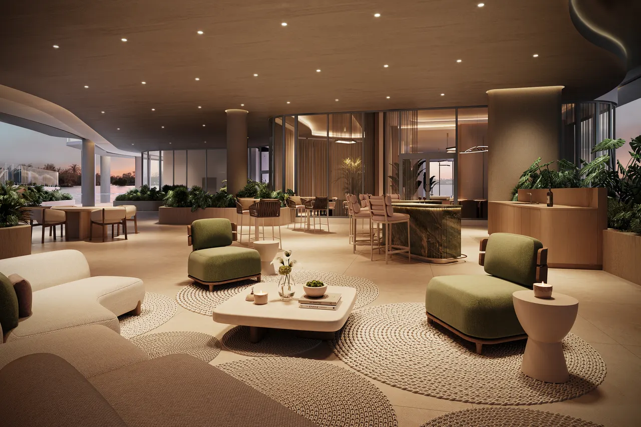 Residents lounge with green armchairs, curved sofas and a stone bar beside floor-to-ceiling glass