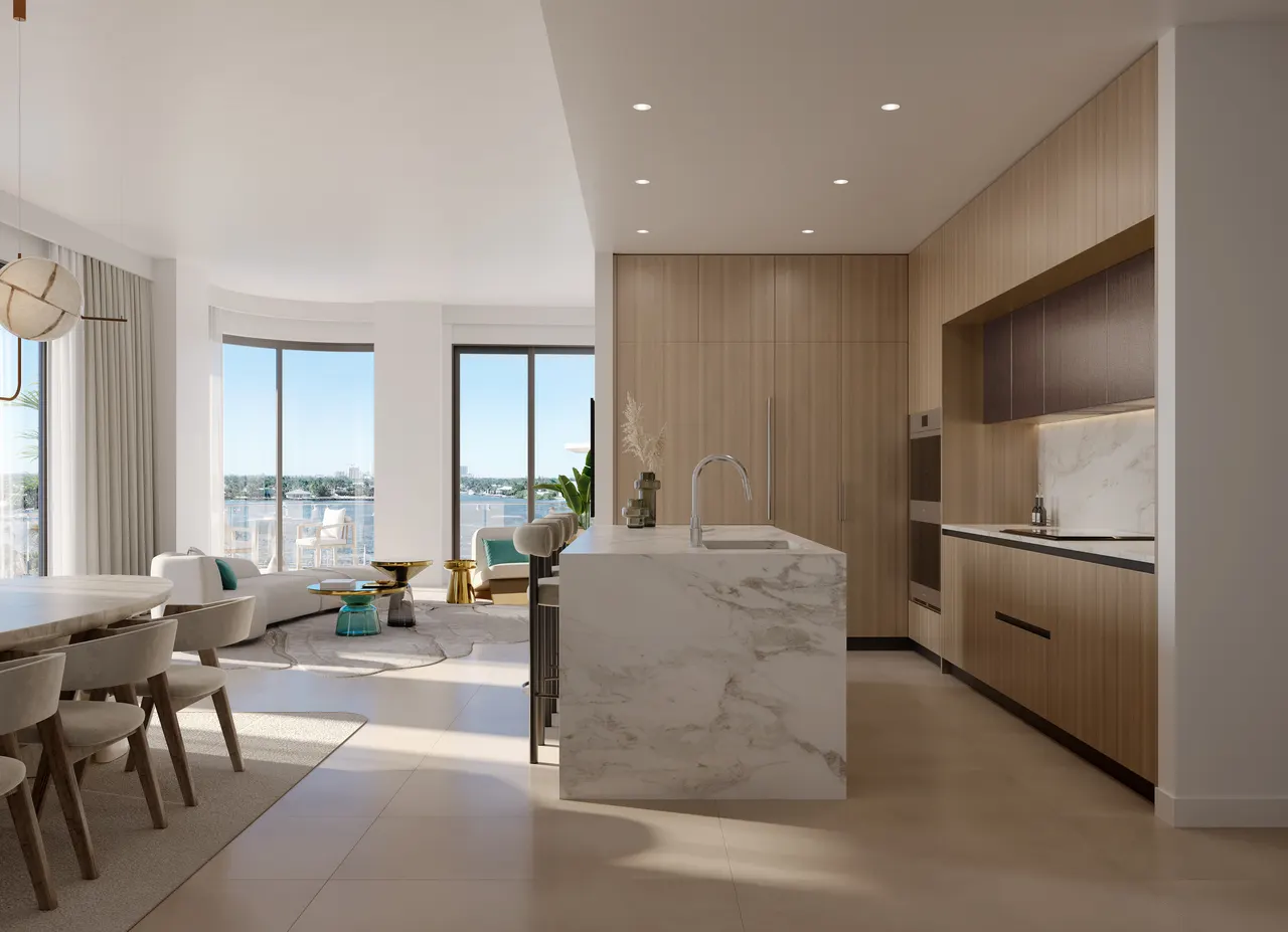 Open kitchen with marble waterfall island and wood cabinetry beside a living area with water views