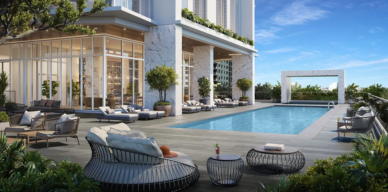 Elevated pool deck with sun loungers, marble columns and a glass lounge beside the tower base