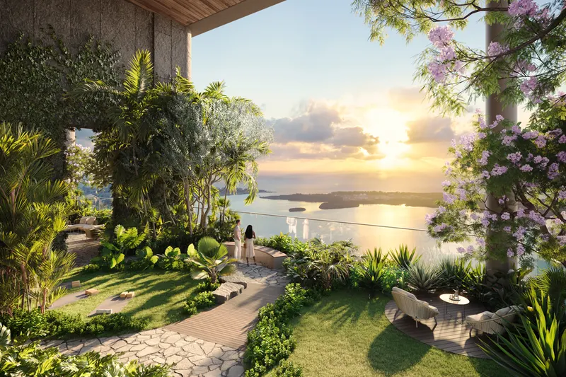 Landscaped sky garden terrace with stone path, flowering trees and water view at sunset