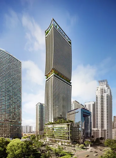 Curved glass tower rising above a landscaped podium and surrounding high-rises in Brickell