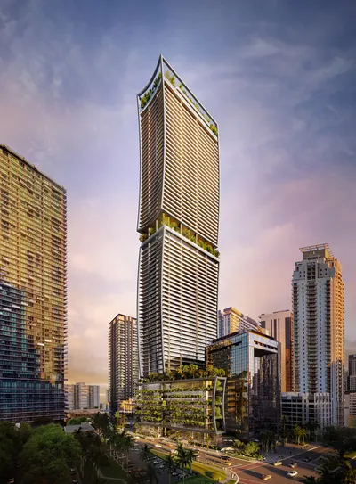 Slender glass tower rising above surrounding high-rises and a landscaped podium at dawn