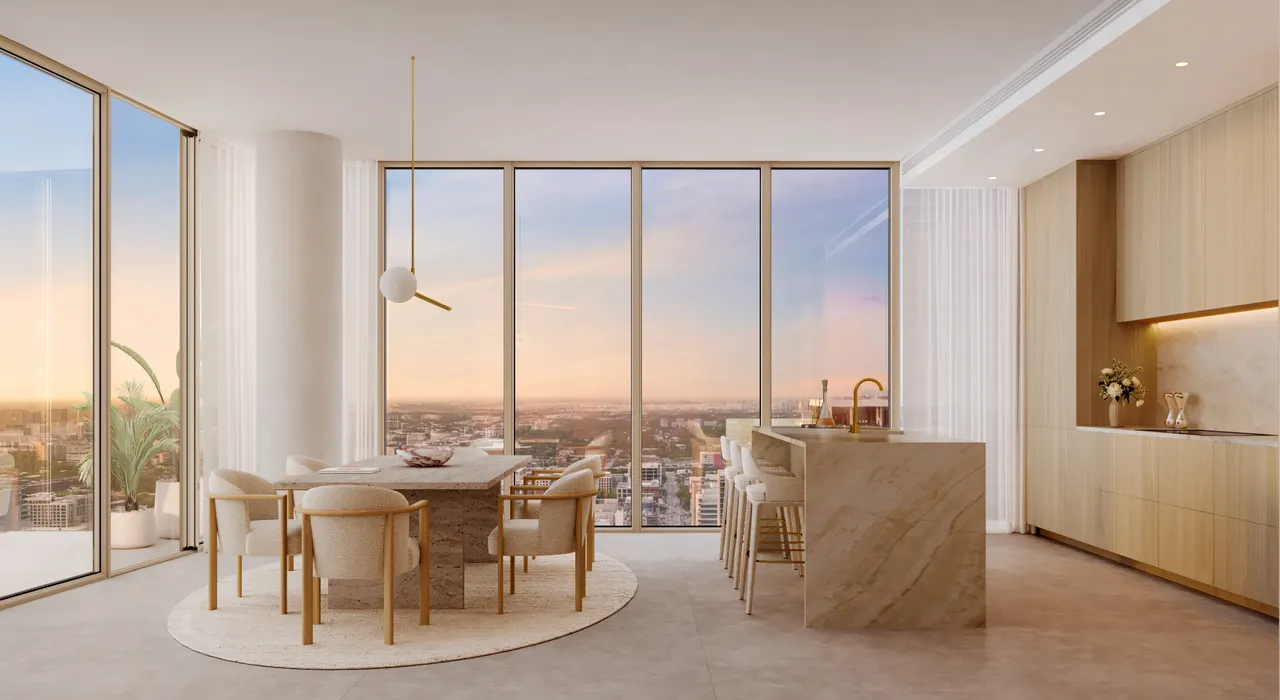 Open dining area and stone waterfall island kitchen framed by floor-to-ceiling windows at sunset