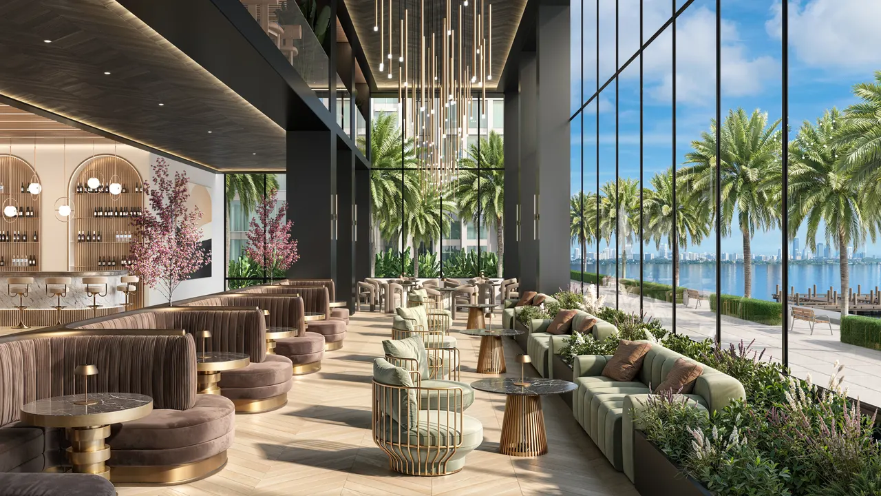 Double-height lounge and bar with velvet banquettes, gold accents and floor-to-ceiling windows facing the water