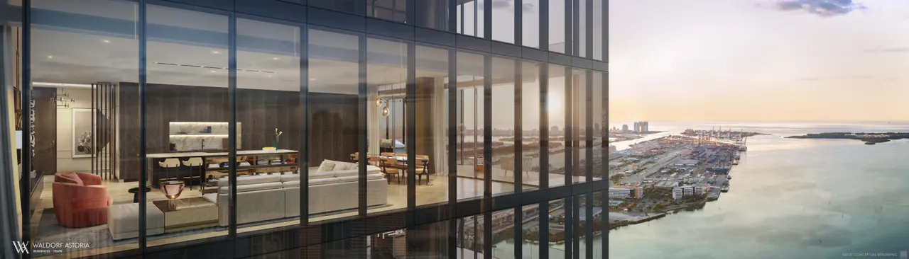 Floor-to-ceiling glass corner of a high-floor Waldorf Astoria residence over the water at sunset