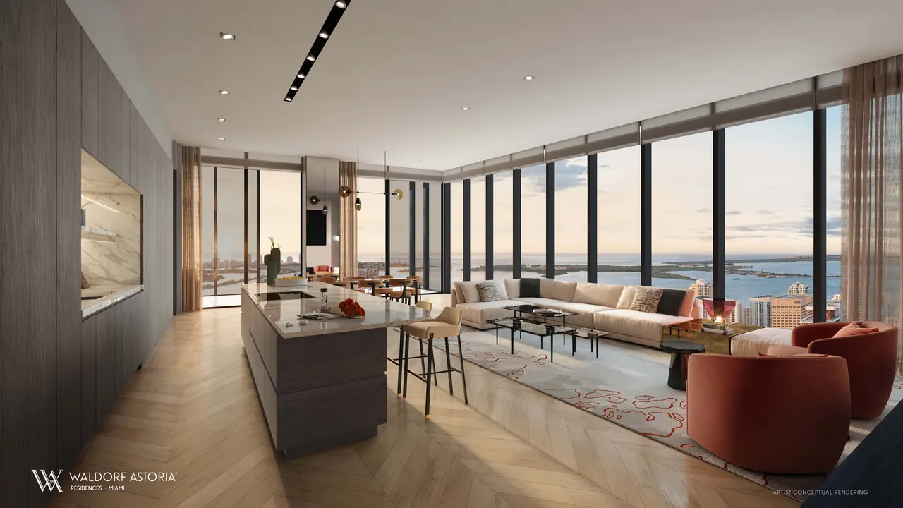 Open living room and island kitchen with floor-to-ceiling windows framing a water view