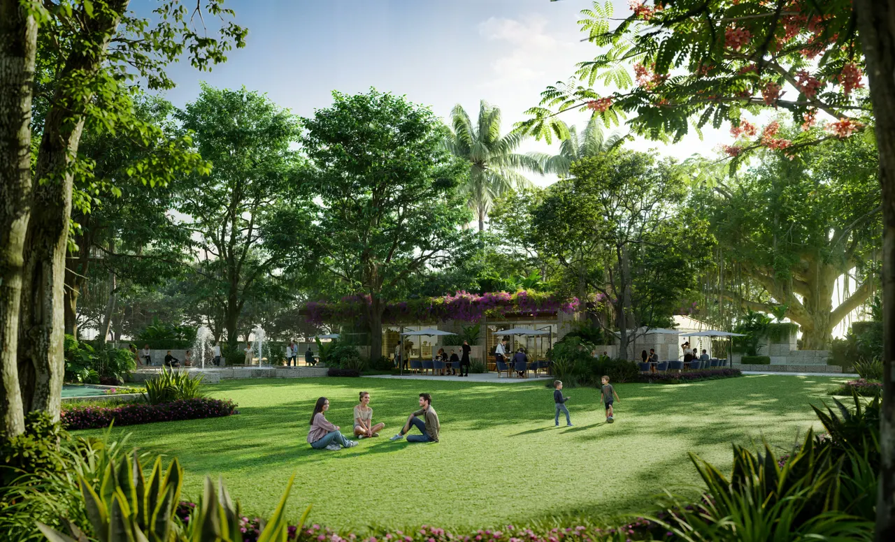 Landscaped park lawn shaded by mature trees with a garden cafe pavilion and tropical planting