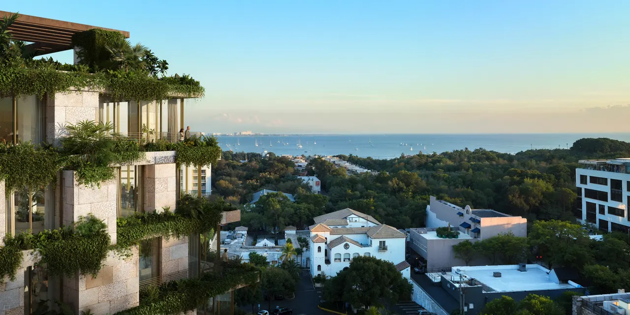 Terraced residences with planted balconies overlooking a tree-filled neighborhood and the water at dusk